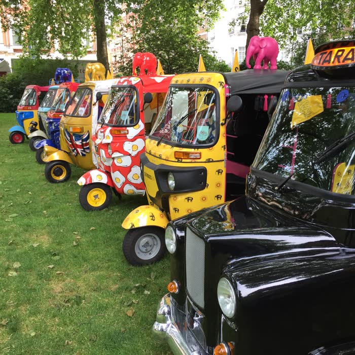 Line-up of artist-designed charity tuk tuks in a London square
