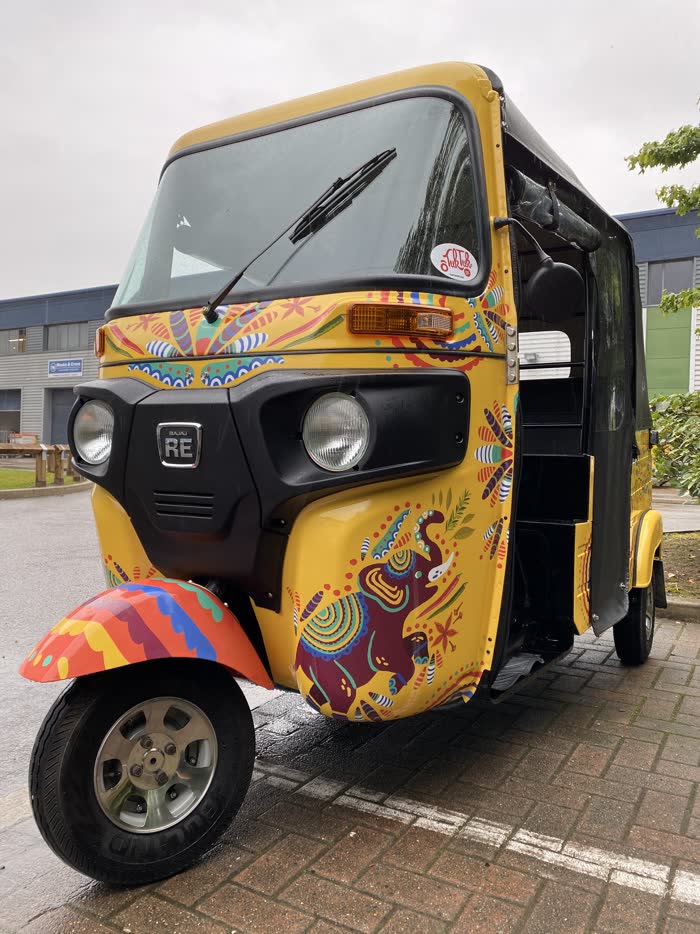 Golden yellow tuk tuk with colourful Sri Lankan artwork