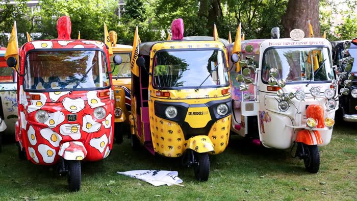 Row of artist-designed tuk tuks including a fried-egg print