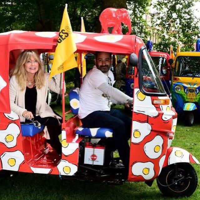 Guests in a fried-egg printed tuk tuk at a charity event
