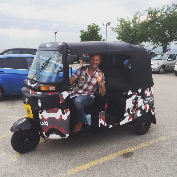 Black and white patterned tuk tuk with its owner
