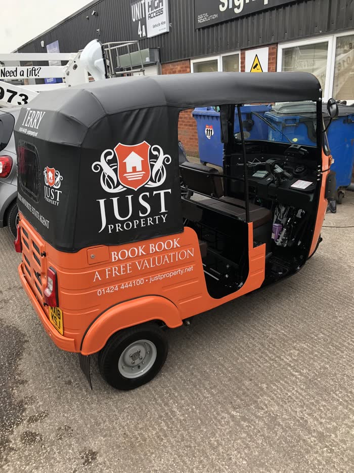 Just Property estate agency tuk tuk in orange and black