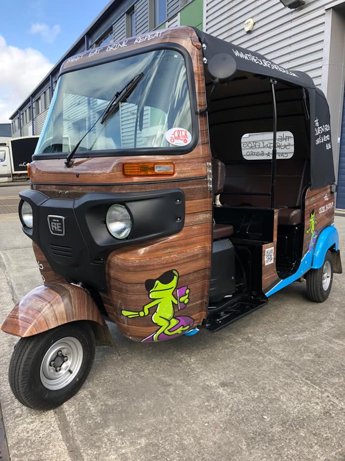 The Surfin' Frog wood-effect wrapped tuk tuk, front three-quarter view